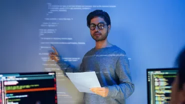 Person presenting coding project on screen with notes.