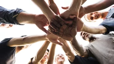Group of people joining hands in a circle